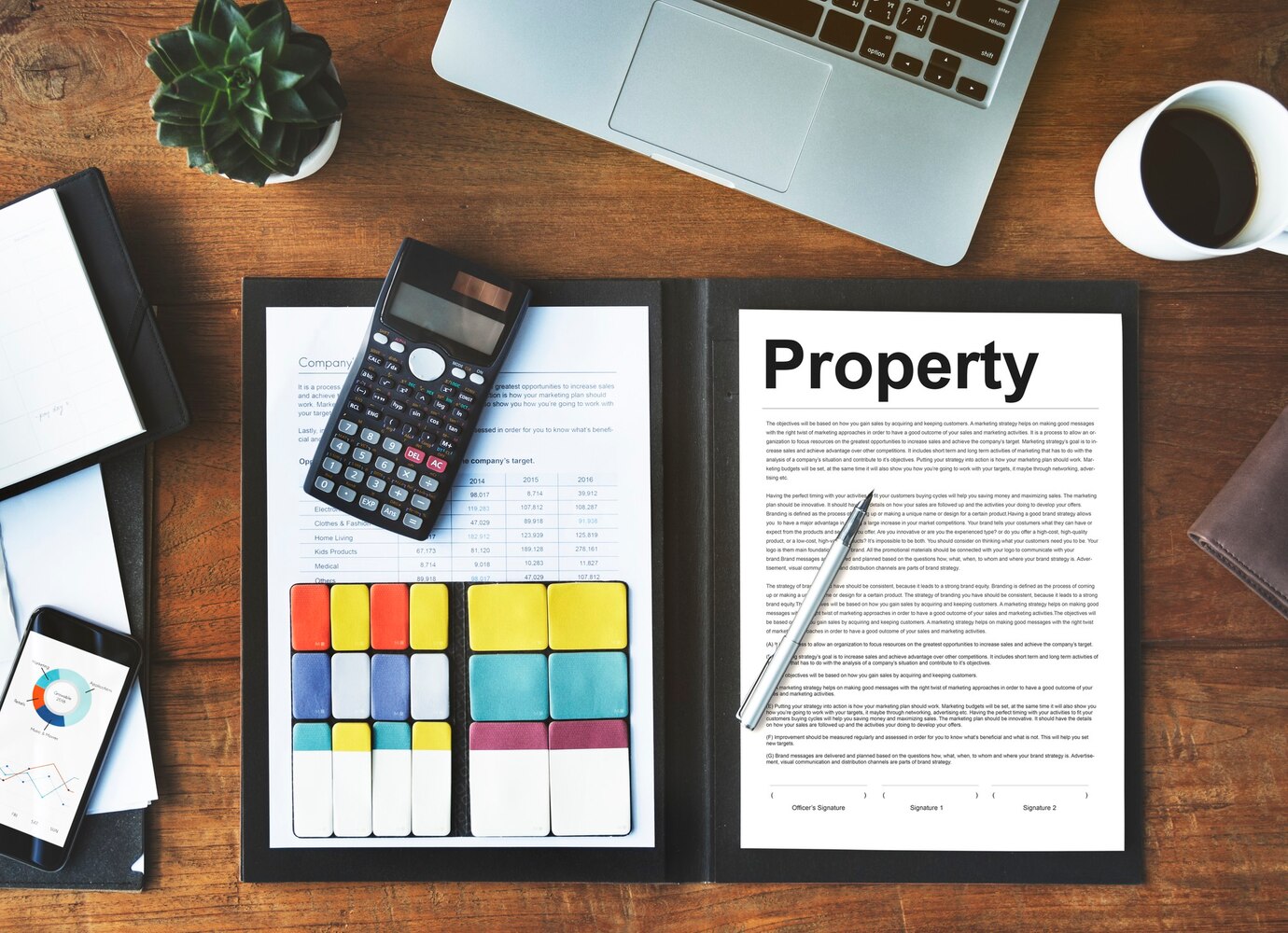 Residential Rental Property Financial Statement Calculator and documents on desk with laptop and plant.