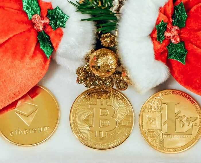 Three cryptocurrency coins with holiday decorations.