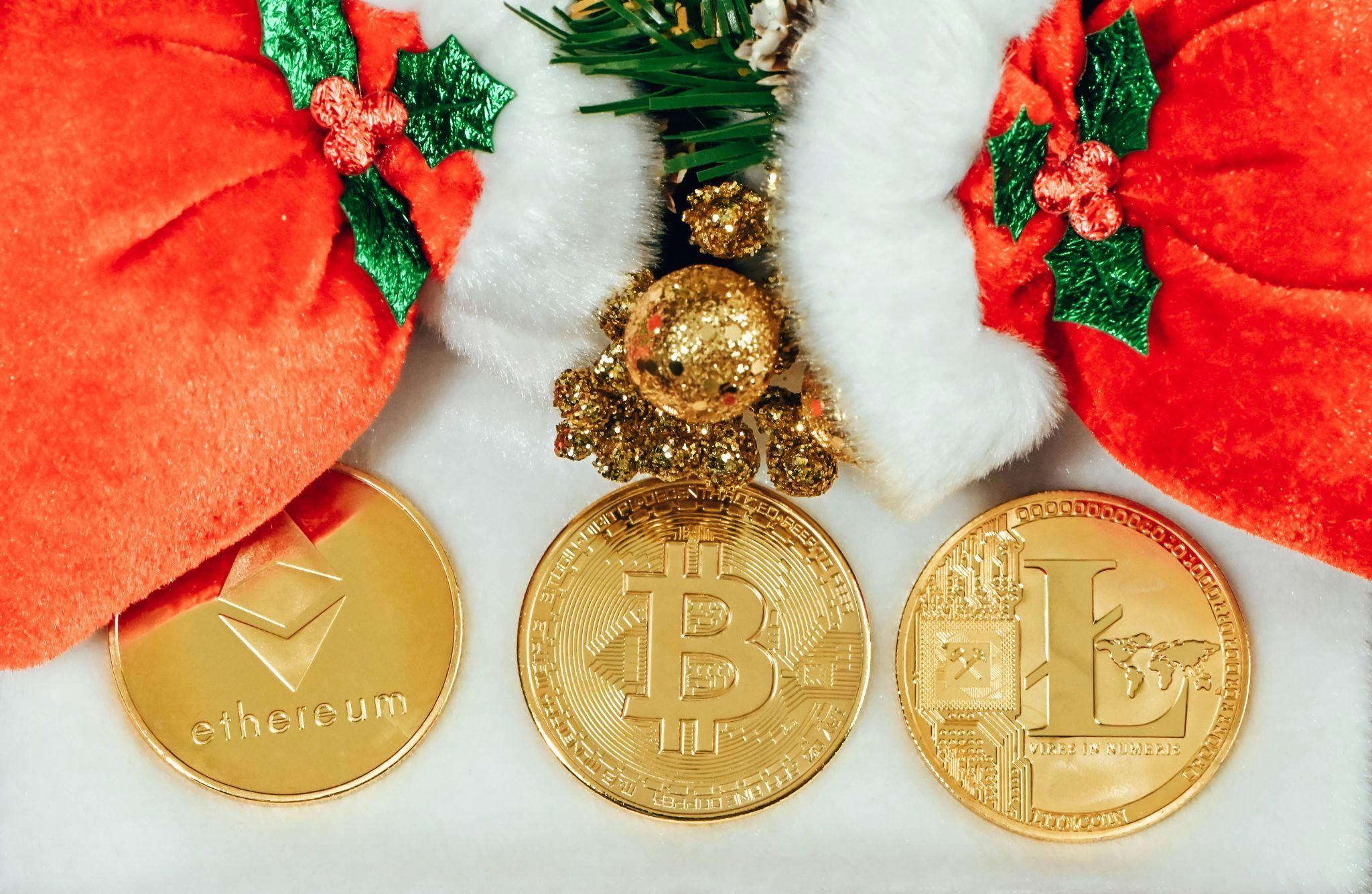 Three cryptocurrency coins with holiday decorations.
