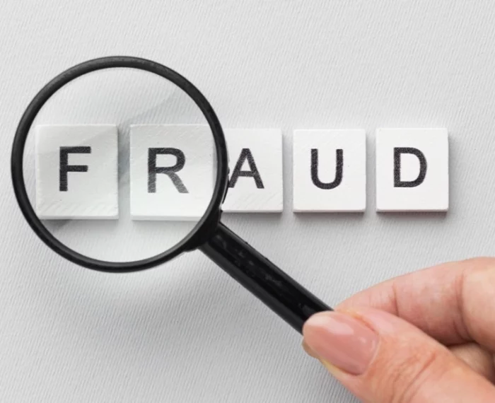 An image with a magnifying glass on the word Fraud